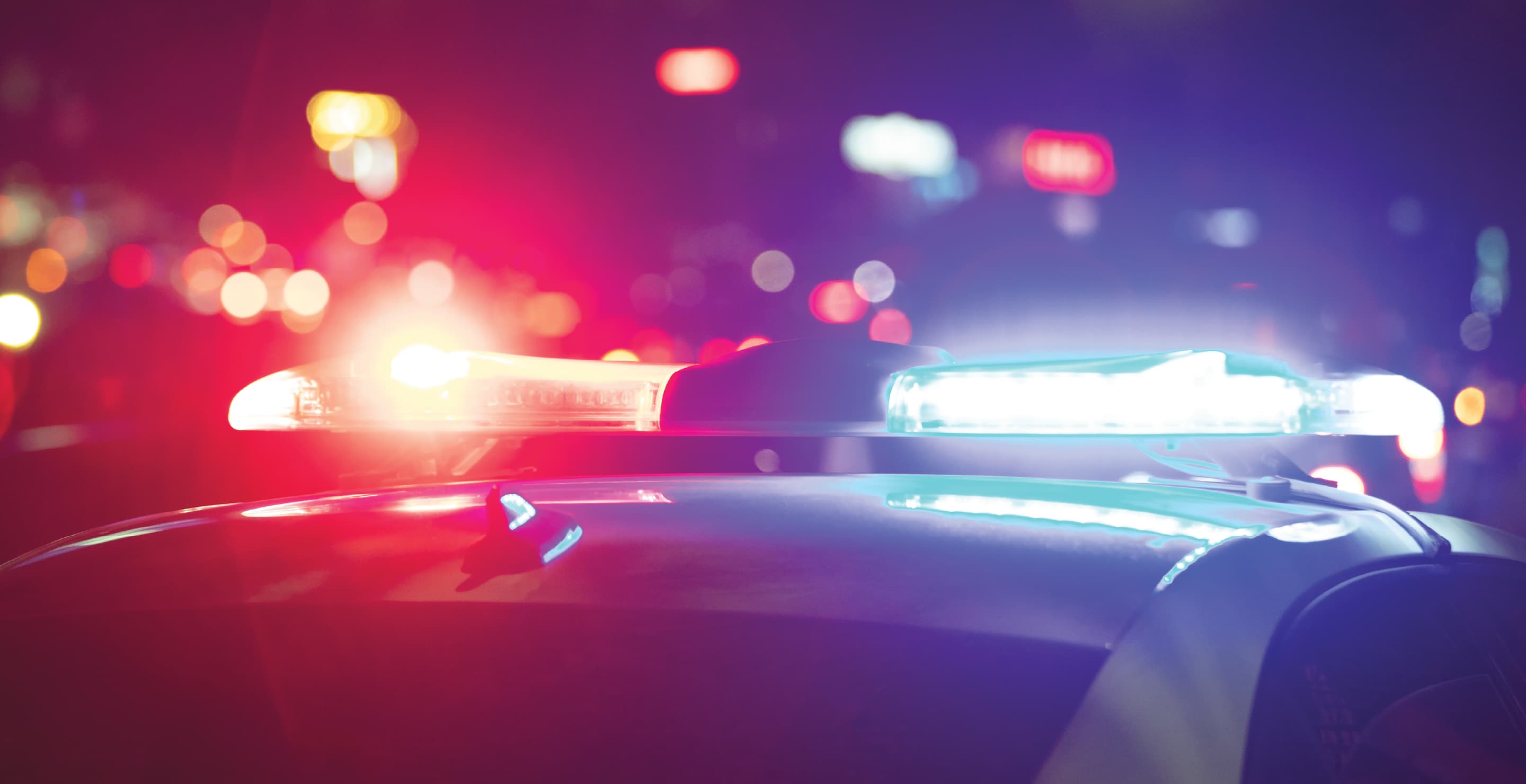 Police Patrol Car Flashing Red And Blue Lights At Night, City