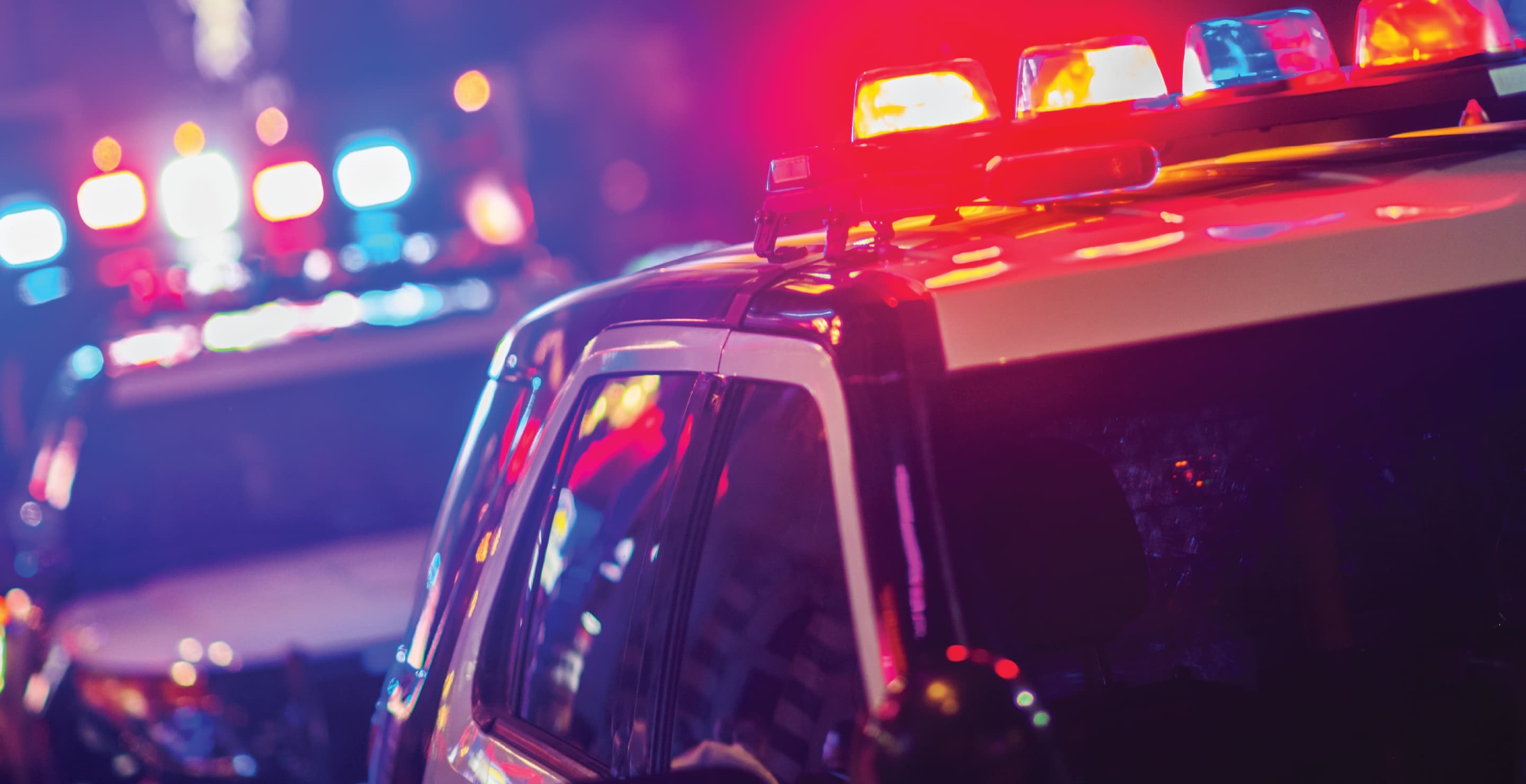 Police Vehicles With Flashing Lights At Night