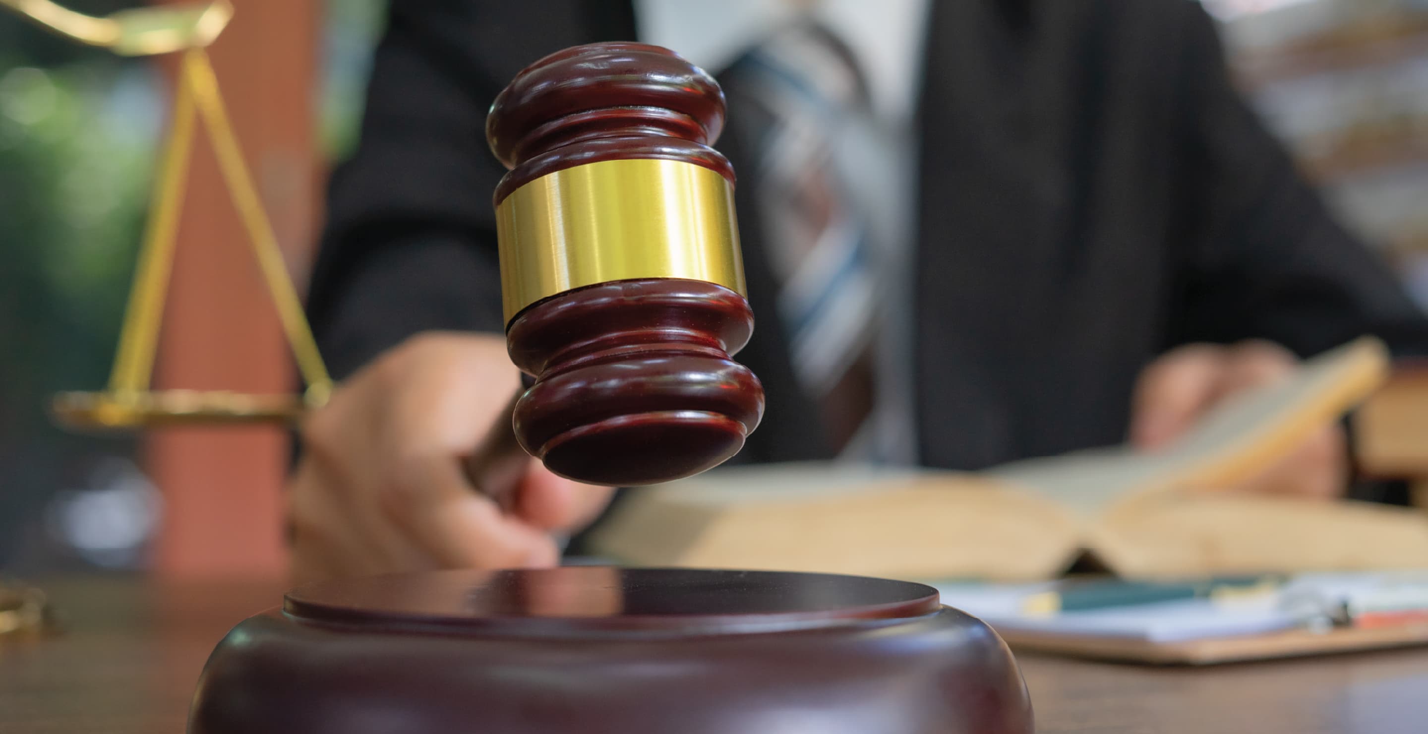 Judge Holding Wooden Gavel On Table