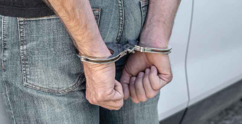 Man Arrested And Handcuffed Next To Car