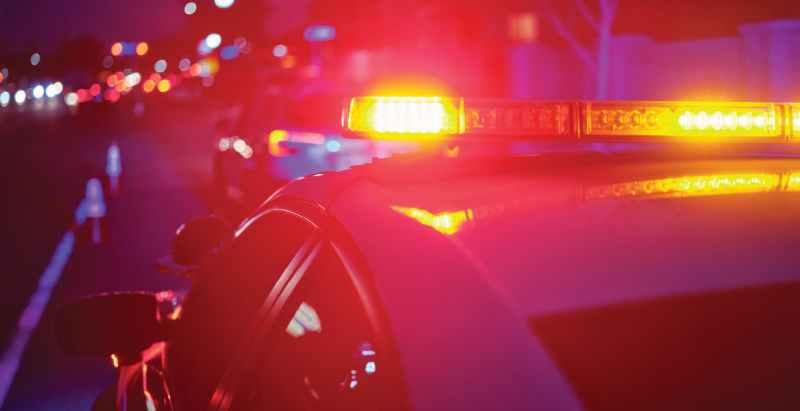 Police Car Stopped On The Road Flashing Lights